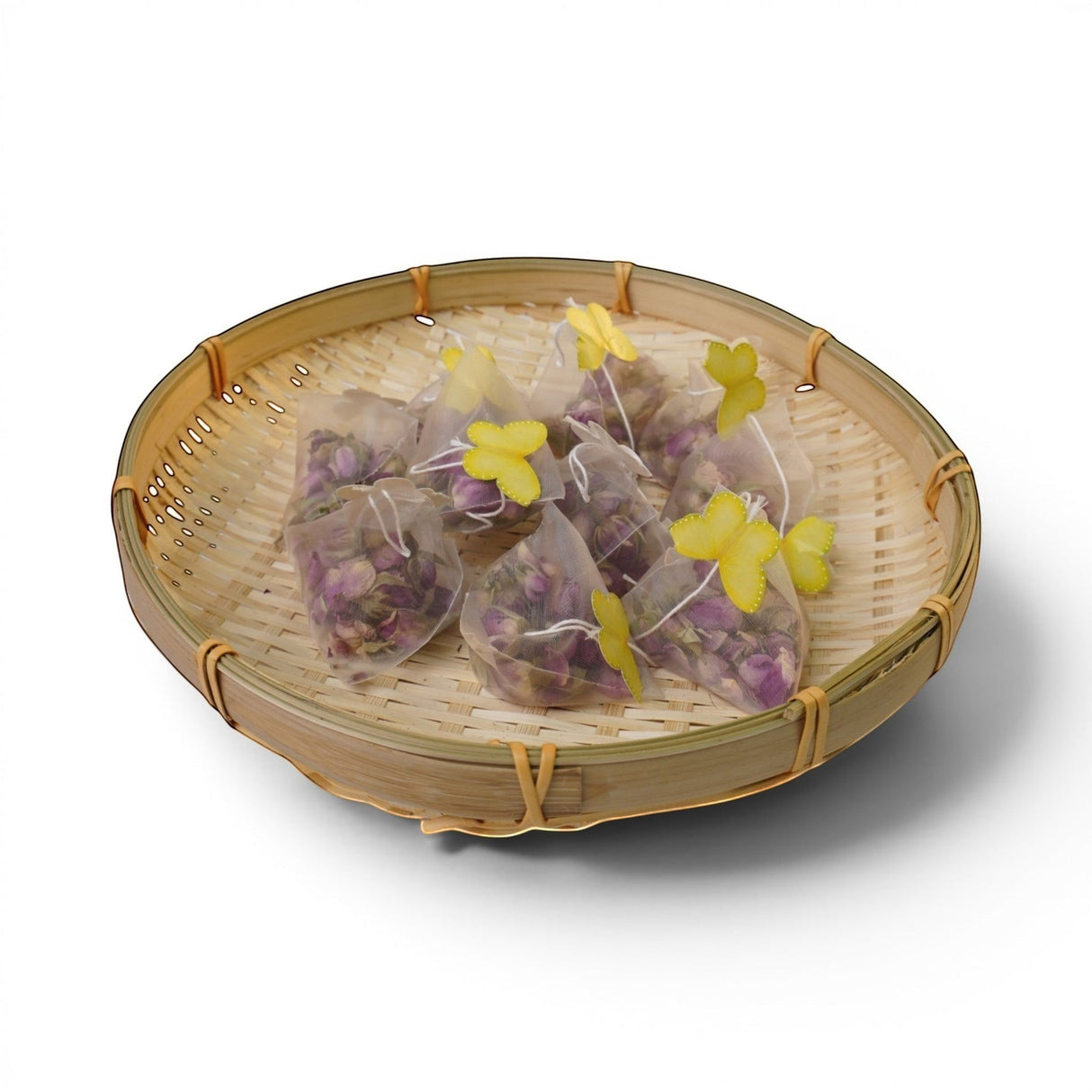 Mahnaz Food Rose Tea sachets filled with dried rose petals, presented in a bamboo basket with yellow butterfly accents.