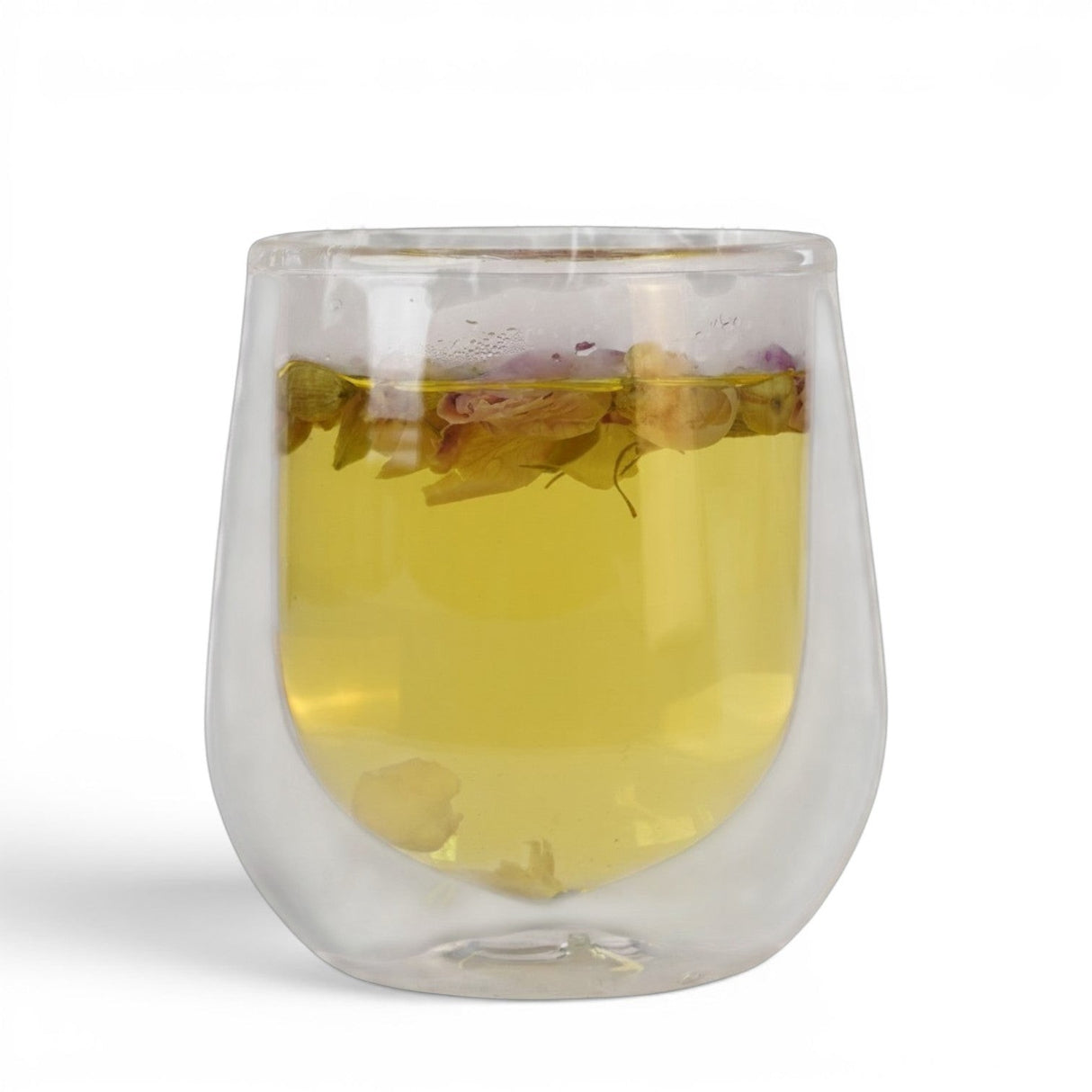 Mahnaz Food Herbal Memory Tea in a double-walled glass cup, featuring rose petals, saffron, and cardamom.