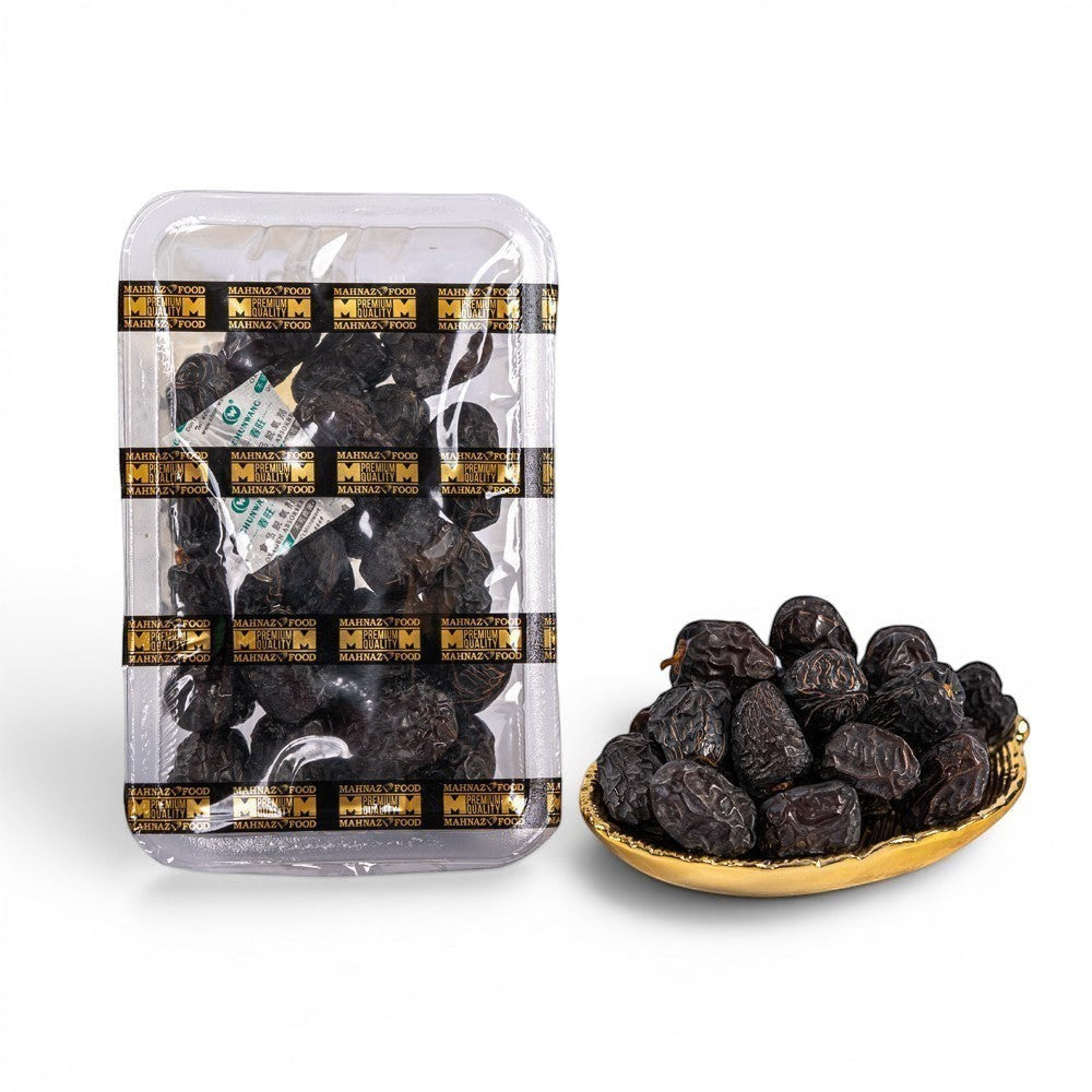 Mahnaz Food Madinah Ajwa dates, dark brown to black with white wrinkles, soft dry fruit. Available in premium and organic grades.
