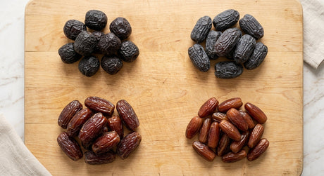Dates of different varieties arranged on a wooden board for comparison