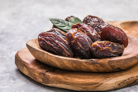 Kurma besar di atas pinggan kayu, salah satu makanan sunnah yang kaya dengan khasiat.