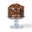 Mahnaz Food dried sultana raisins piled high in a clear glass pedestal bowl against a white background.