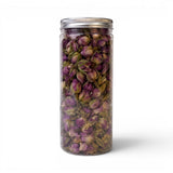 Mahnaz Food rose petals herbal tea in a clear jar. Loose leaf tea with dried pink rose buds and green stems.