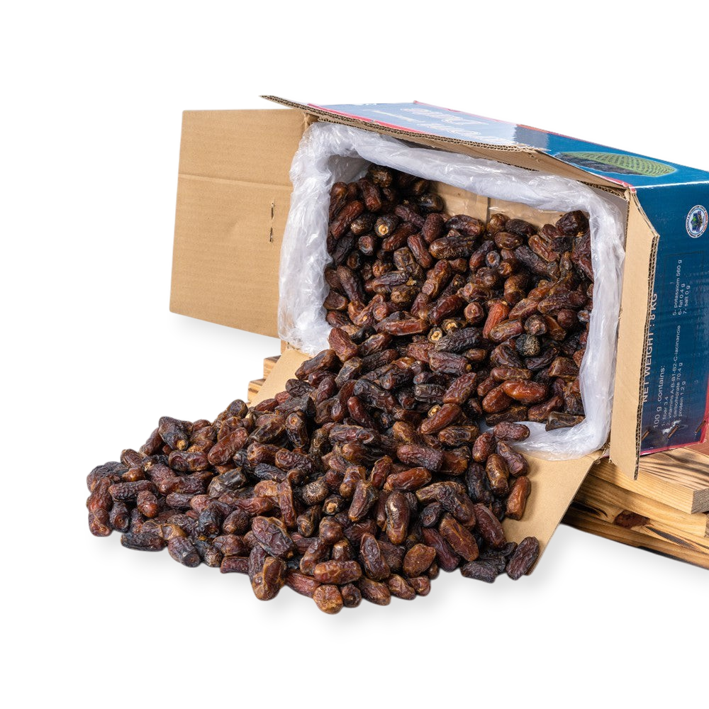 Mahnaz Food premium Mariami dates spilled from a wholesale cardboard box on a white background