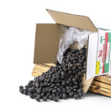 Mahnaz Food premium Ajwa dates spilling from a cardboard box. Dark brown, soft, and naturally sweet.