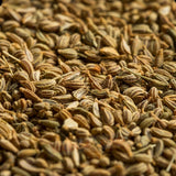 Close-up of premium Mahnaz Food Ajwain seeds with a textured, brownish-green appearance for cooking and baking.
