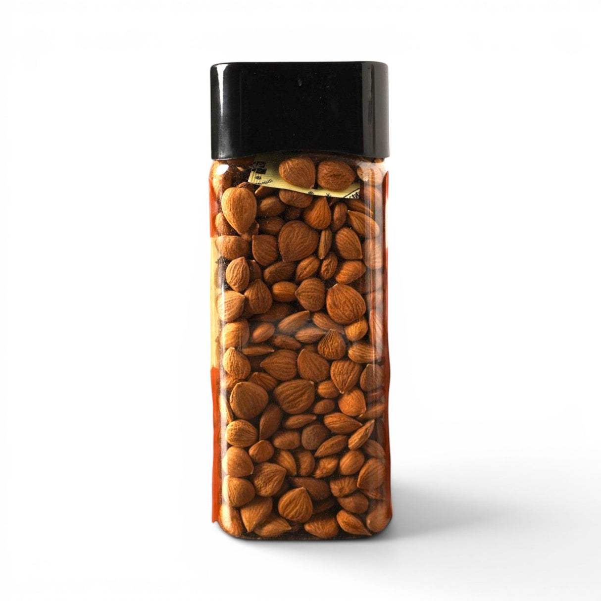 Mahnaz Food apricot seeds in a clear rectangular plastic jar with a black lid, perfect for snacking or baking.