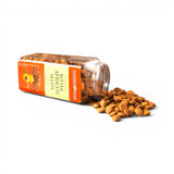 Mahnaz Food bitter apricot seeds in a clear plastic jar spilling out onto a white surface for a healthy snack