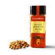 Mahnaz Food bitter apricot seeds in a clear plastic jar with a pile of crunchy kernels on a white background.