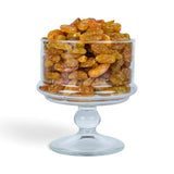 Mahnaz Food golden jumbo raisins piled high in a clear glass pedestal bowl against a white background