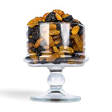 Mahnaz Food jumbo black and golden raisins served in a clear glass pedestal bowl on a white background