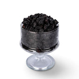 Mahnaz Food jumbo black raisins served in a clear glass pedestal bowl against a white background
