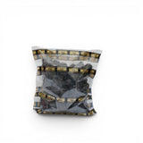 Mahnaz Food Madinah Ajwa dates are dark brown, soft, and wrinkled, packaged in a clear bag with branded tape.