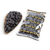 Mahnaz Food Madinah Ajwa dates are dark brown, wrinkled, and soft. Available in a decorative bowl and a clear plastic bag.