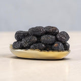 Mahnaz Food Madinah Ajwa dates are dark brown to black, soft, and wrinkled. Available in large to jumbo sizes.