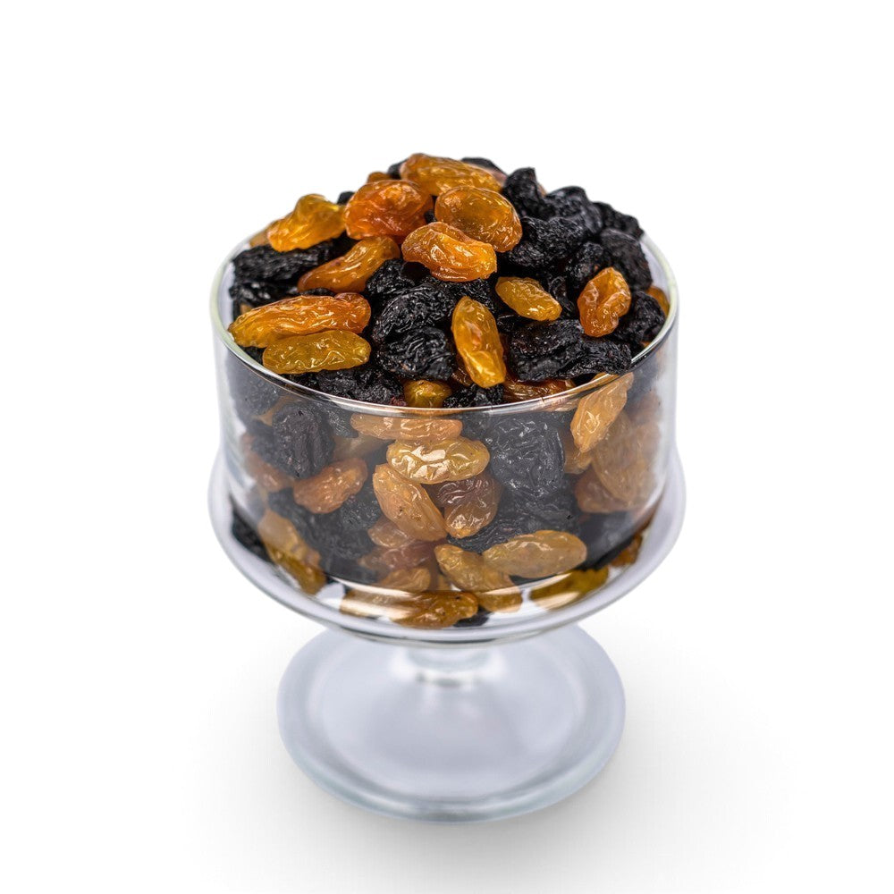 Mahnaz Food jumbo black and golden raisins mixed in a clear glass bowl on a white background