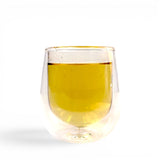 Mahnaz Food Nettle Tea, a golden herbal infusion in a clear double-walled glass, perfect for daily wellness.